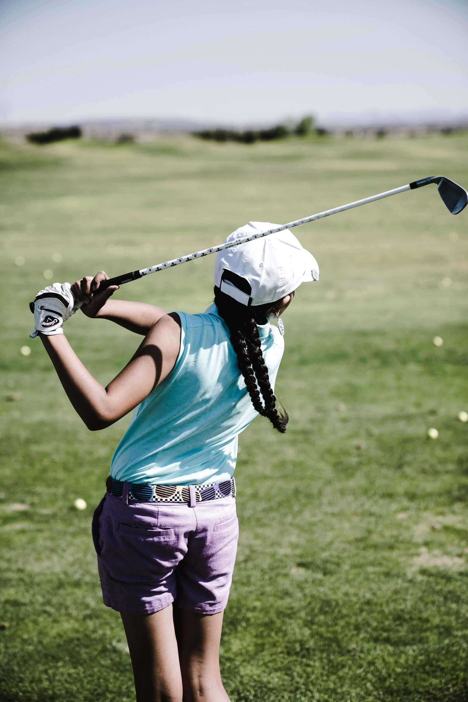 girl swinging golf club